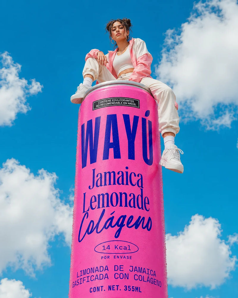 Persona sentada sobre una lata gigante de Wayú