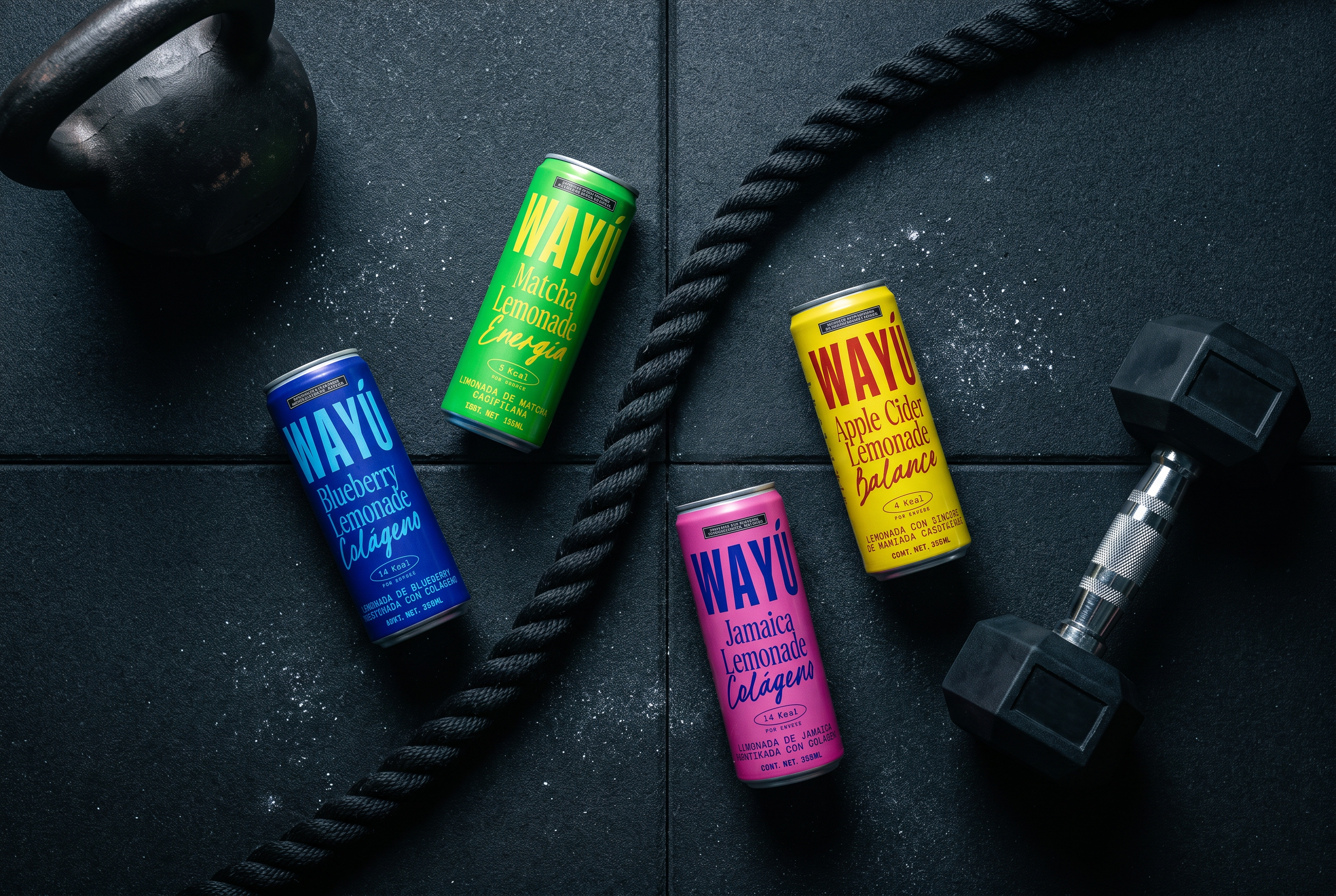 Latas Wayú de Matcha, Blueberry, Apple Cider y Jamaica en el gym junto a cuerda y mancuerna: bebida funcional para antes y después de entrenar