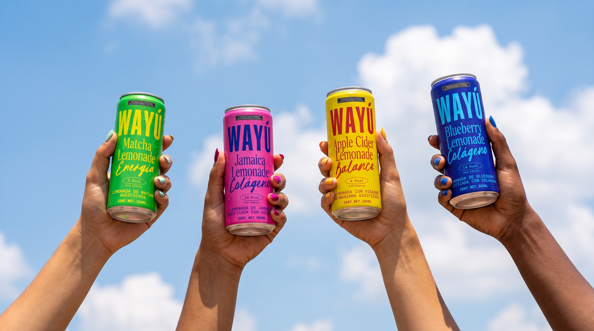 Manos levantando latas Wayú de Matcha, Jamaica, Apple Cider y Blueberry Lemonade contra el cielo: limonadas funcionales hechas en Guadalajara, México